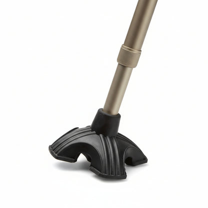 Walking stick fitted with Max Mobility Alpha Quad‑Leg Cane Tip standing upright on a flat floor